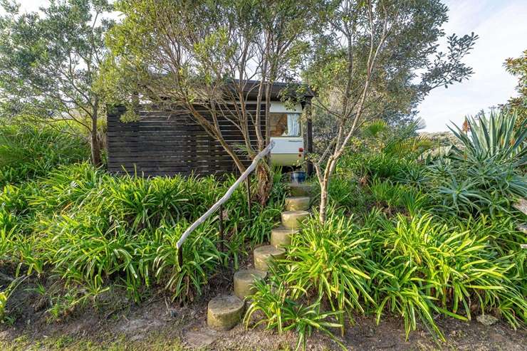 A cute two-bedroom beachfront bach at 122 Mangakahia Drive, in Whangapoua, is looking for a buyer with more than $3.2m to spend. Photo / Supplied