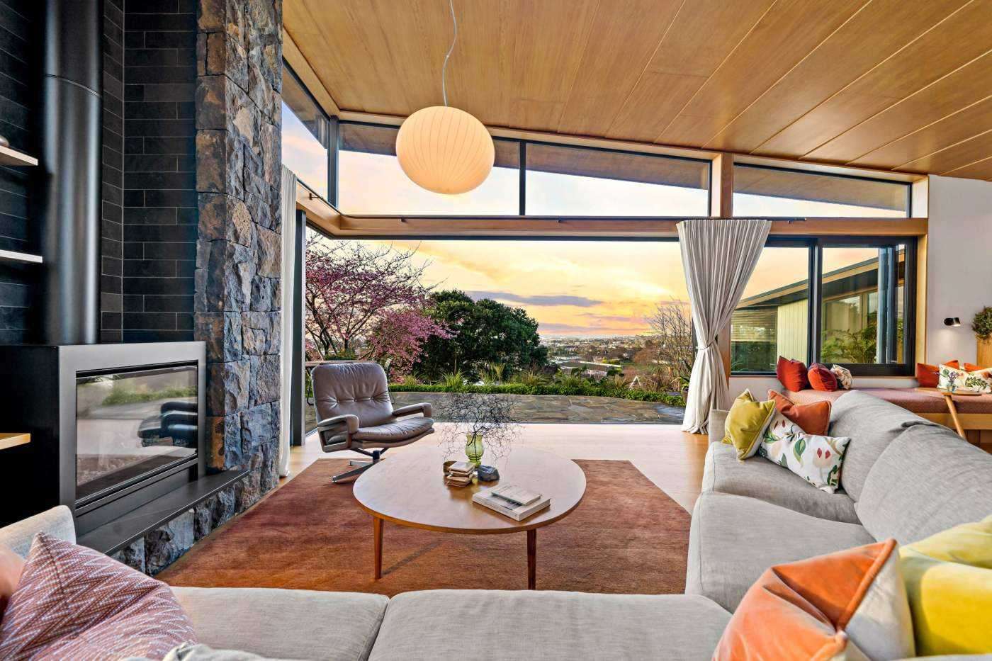 mid century modern-style house with stone fire place wood ceiling sunset view  33 Market Road, Remuera, Auckland