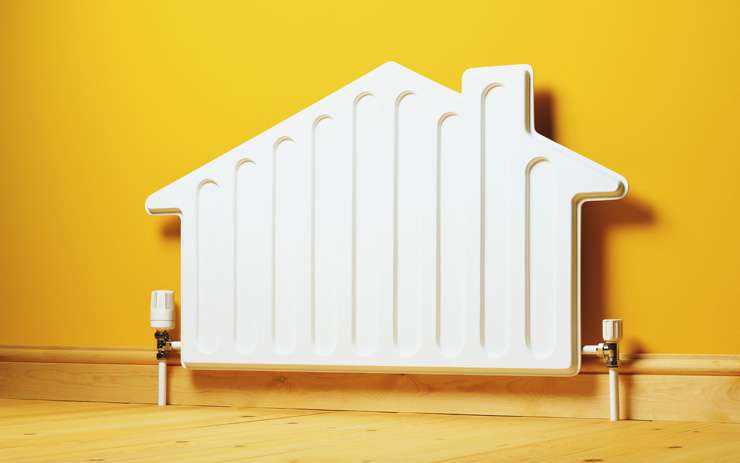 A child sits by the window next to a central heating panel