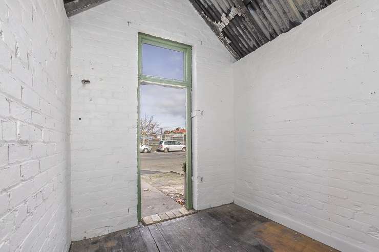 Green brick shed with pink poster on wall  1A Tuarangi Road, Grey Lynn, Auckland