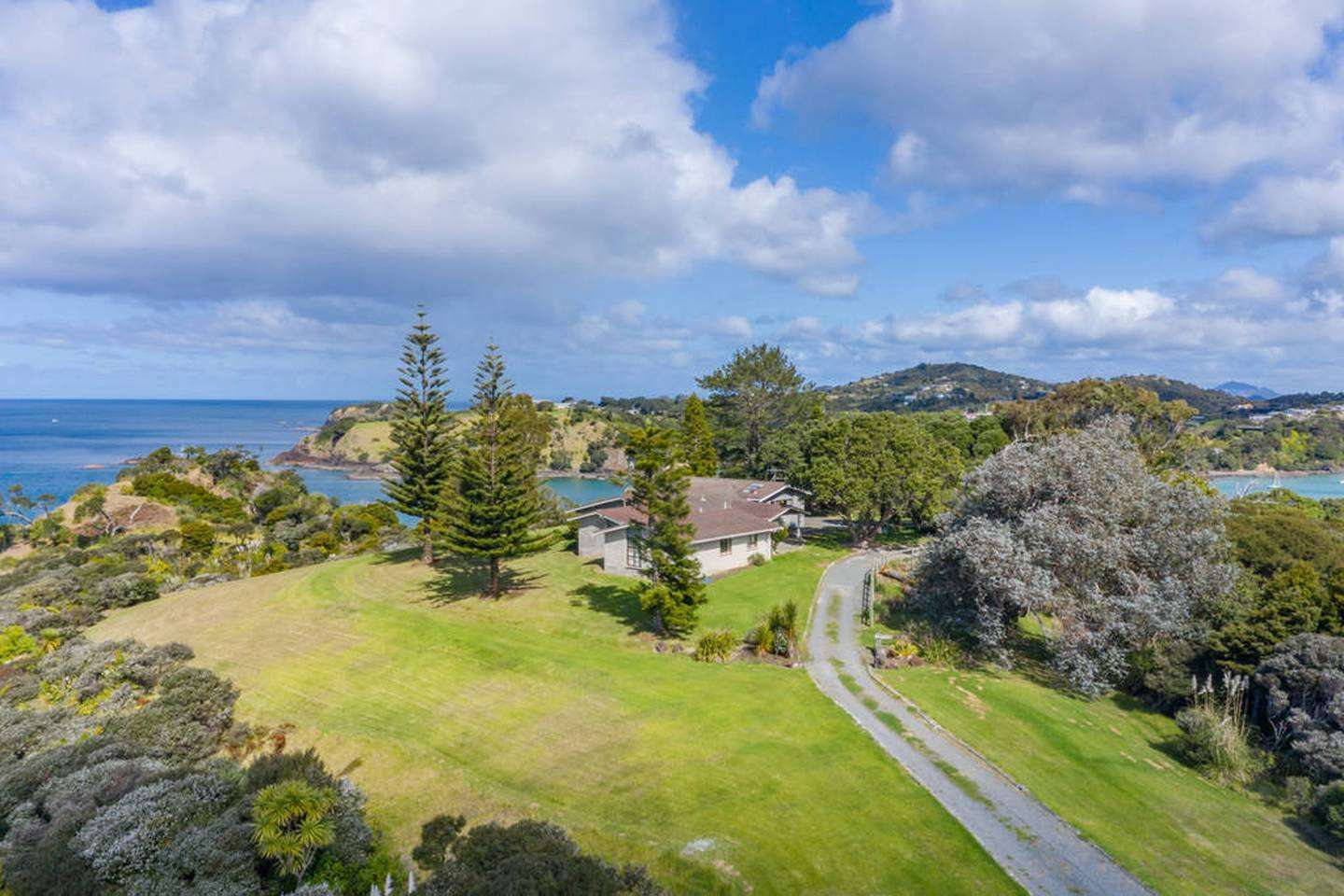 large house with circular rooms and turrets on coastal Northland property