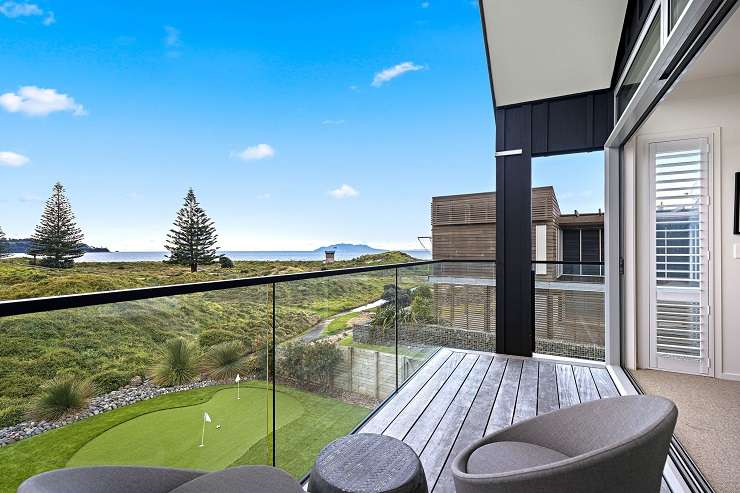 pair of black two-storied wings with green lawn and dunes in front  8 Tio Lane, Omaha, Auckland