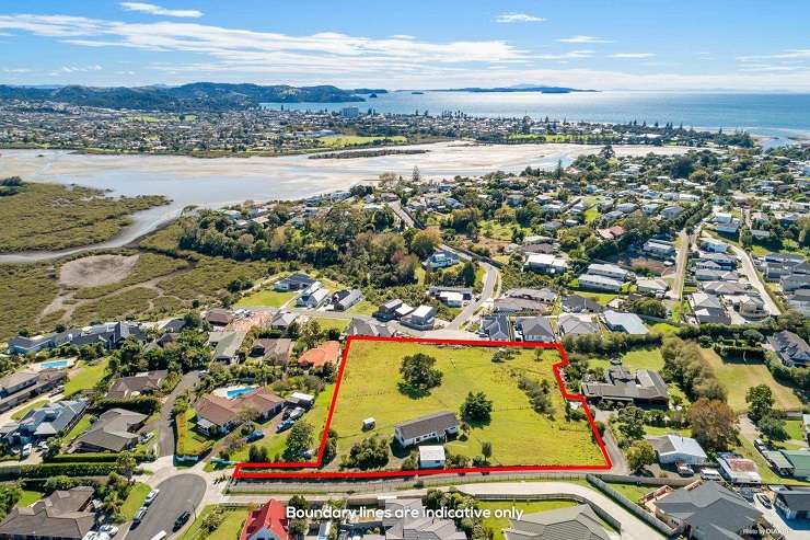 green field and white house with garage 86 Matija Place, Red Beach, Rodney, Auckland