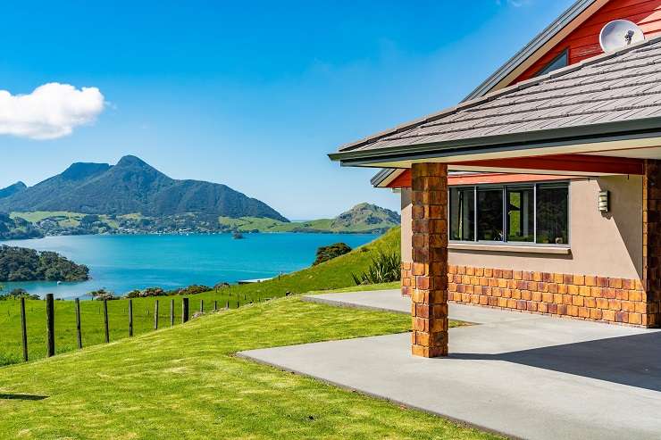 aerial view of waterfront homes, boats, Mount Manaia and Whangarei in the background