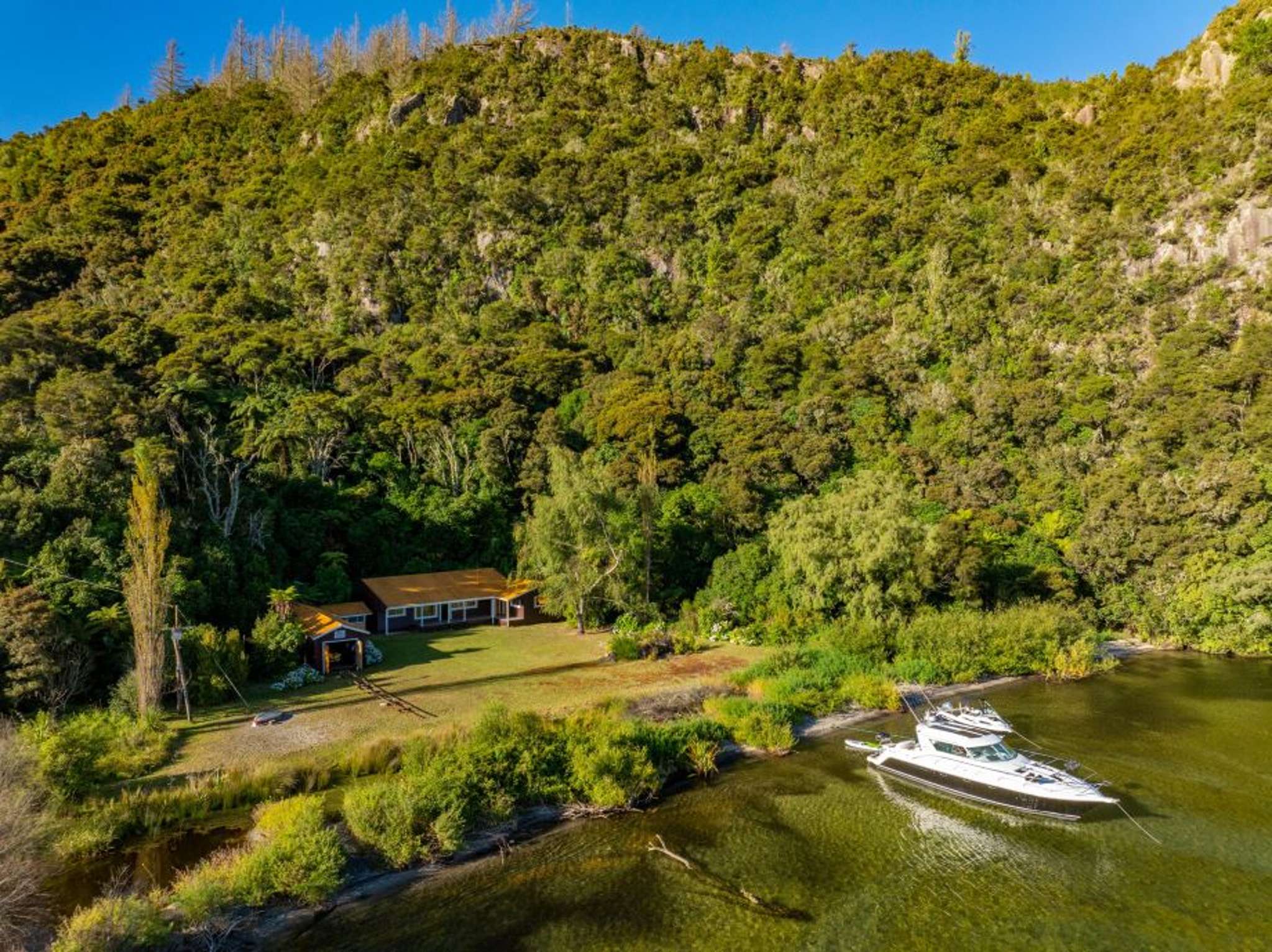 Secluded waterfront bach that hosted a future king and a notorious escapee is for sale