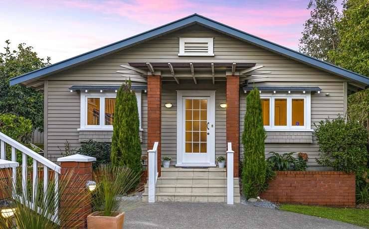 Cream house with grey roof on spreading lawn with swimming pool 51 Maungakiekie Avenue Mount Eden