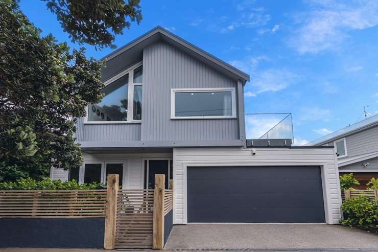 blue cottage with white windows and red door 197 Marine Parade Seatoun Wellington