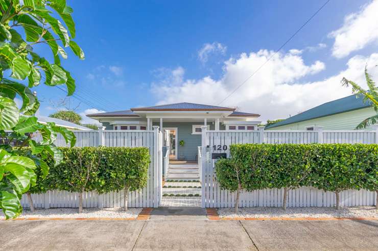 pale green villa with white trim and lights on 74 Vermont Street Grey Lynn Auckland