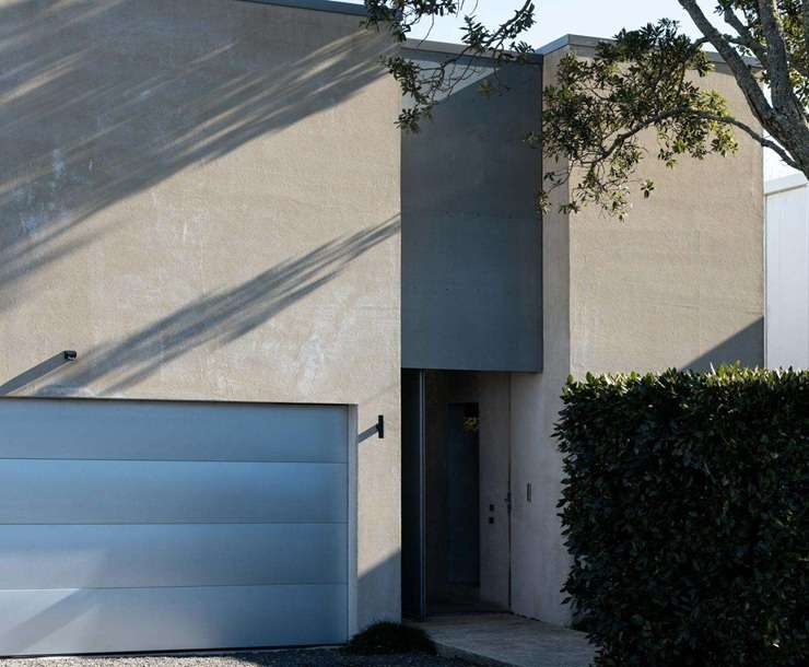 1 Albany Road, in Auckland's Herne Bay, is a modern concrete house that shares its grounds with a heritage brick stable. It is back on the market after three years. Photo / Supplied