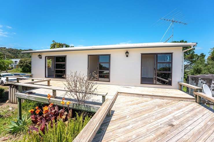 6 Kowhai Street Takapuna  A modern square cedar and concrete house with hedge and driveway in front