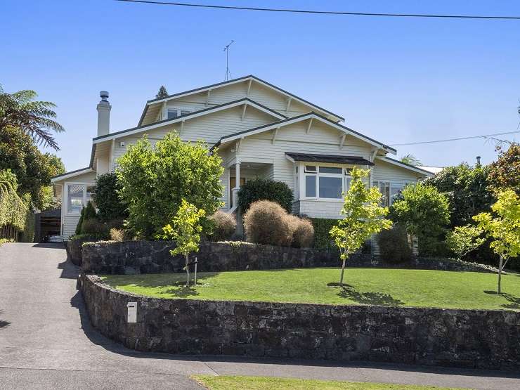 Grey villa with white picket fence and hedge at 23 Cheltenham Road, Devonport