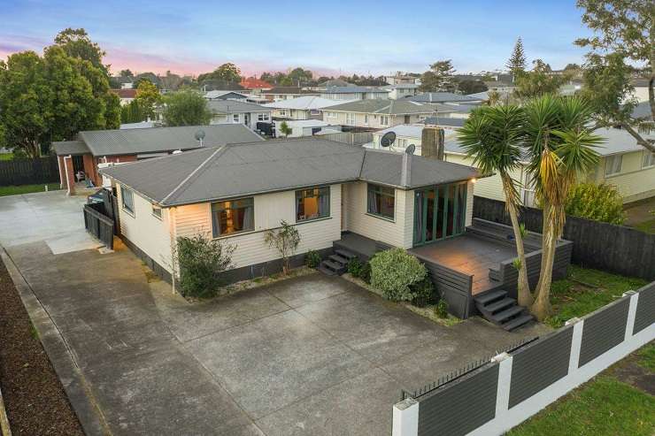 run down house with car and gravel driveway