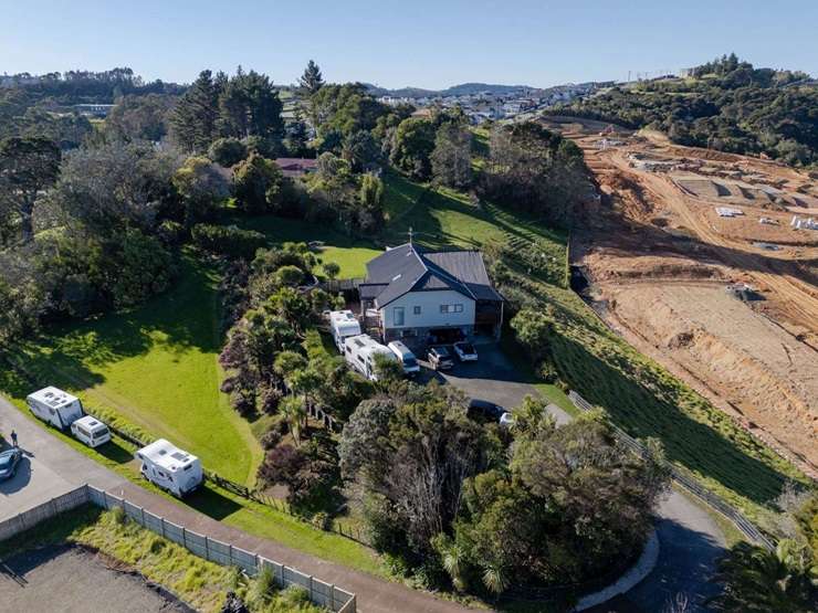 On the market for sale, with its three neighbours, is 240 West Hoe Heights, in Orewa. Earthworks for a housing development can be seen in the background. Photo / Supplied