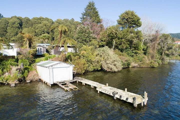 cedar house with lights and decks in foreground 257A Whangamoa Drive, Lake Rotoiti, Rotorua