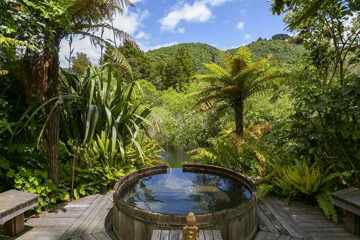 The three-bedroom, two-bathroom home at 23 Humu Street, in Tokaanu, has direct access to a stream and its own geothermal hot tub. Photo / Supplied