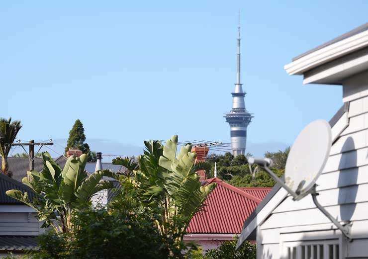 Pedestrians walk past a bank in Auckland