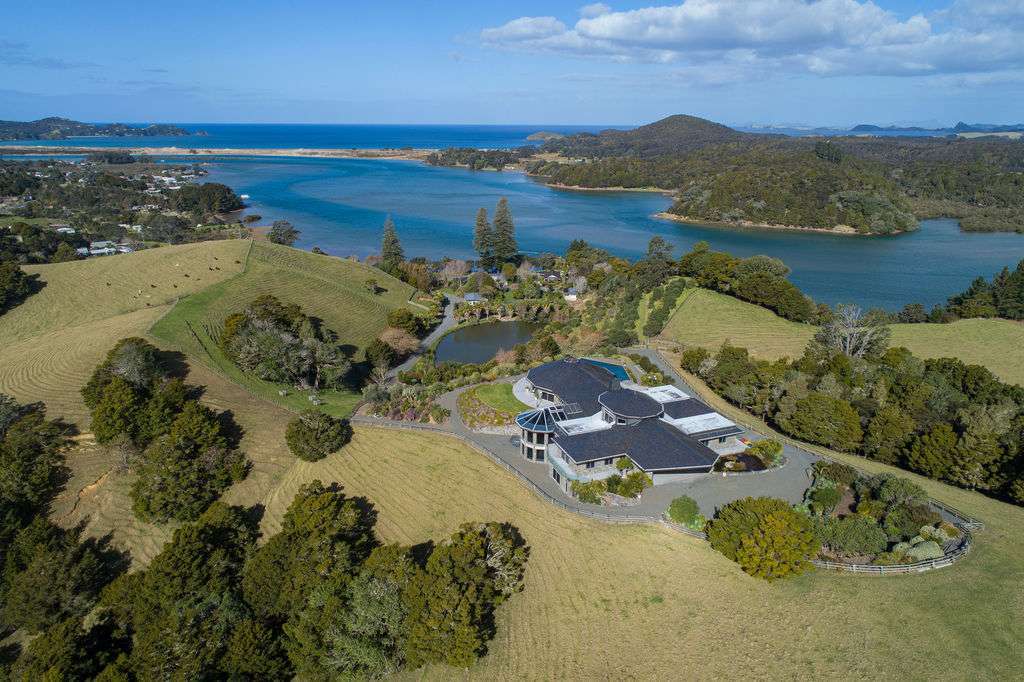 large house with circular rooms and turrets on coastal Northland property