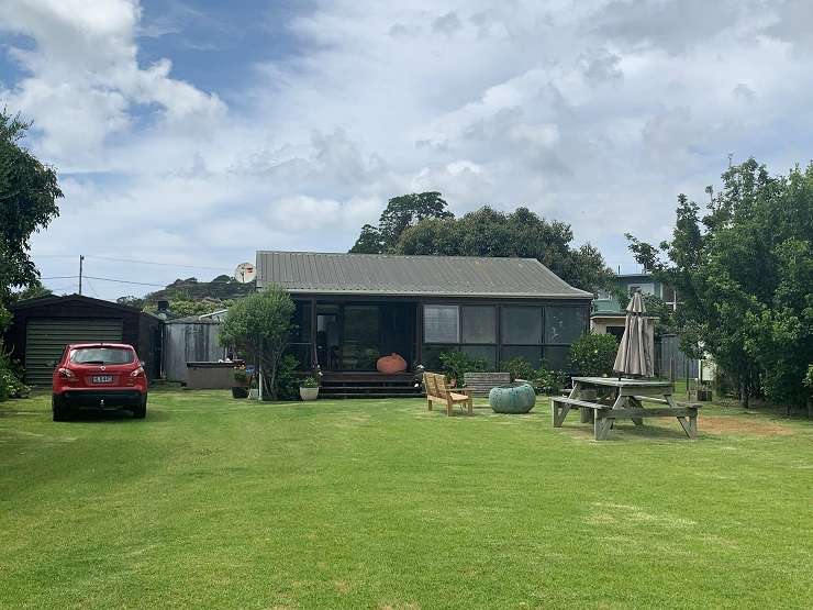 a modern bach with lawn and blue sky behind 77 Pacific Bay Road Tutukaka Northland