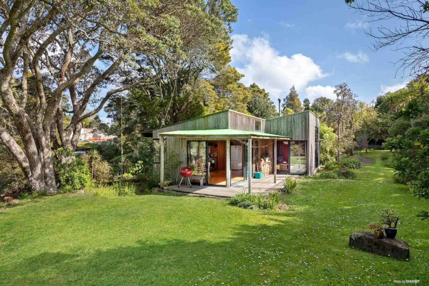 black house with bush behind and lights on  32 Seacombe Road, Point Chevalier, Auckland