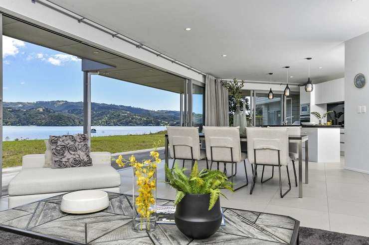 modern house and decking overlooking lawn and water  251 Omaha Drive, Omaha, Auckland