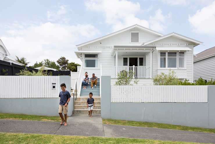 Pedestrians walk past a real estate office in Warkworth