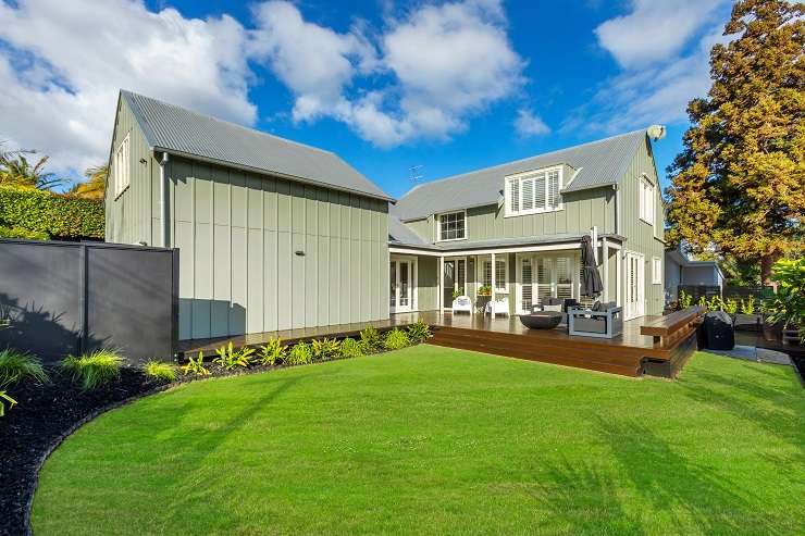 White bay fronted villa with garage doors downstairs and palm tree   177A Avondale Road, Avondale, Auckland