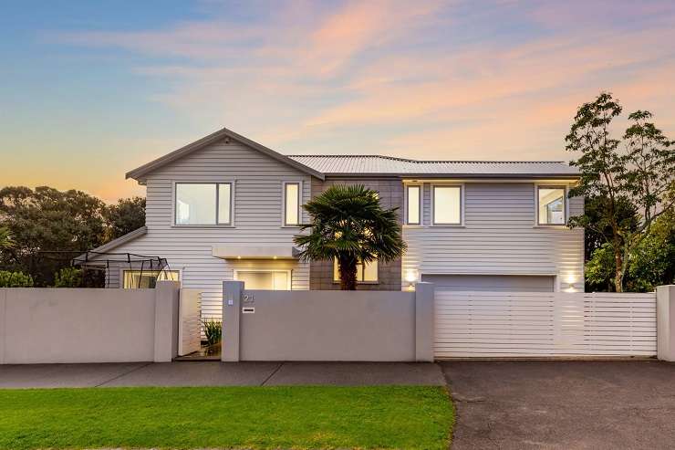 White bay fronted villa with garage doors downstairs and palm tree   177A Avondale Road, Avondale, Auckland