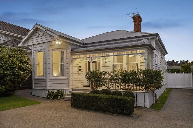 pale green villa with white trim and lights on 74 Vermont Street Grey Lynn Auckland