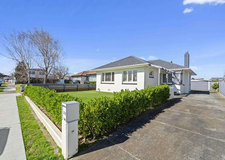 Mike King high-fives his agent after his cottage on Glen Avenue, in Papatoetoe, sold under the hammer. Photo / Supplied