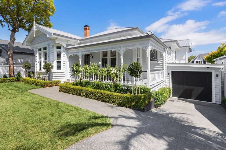 Cream house with grey roof on spreading lawn with swimming pool 51 Maungakiekie Avenue Mount Eden