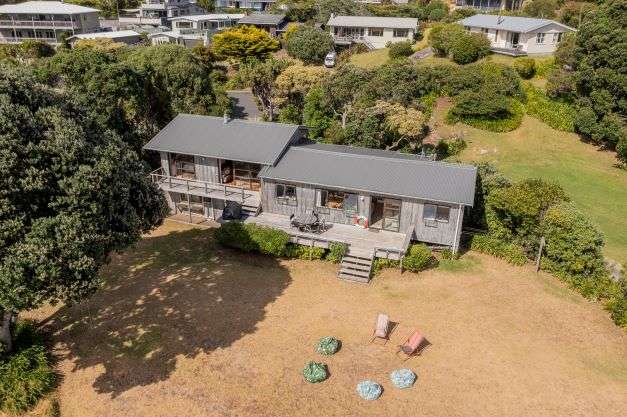 two chairs and bean bags on lawn of 8 Bay View Place in Ferry Landing, Thames-Coromandel