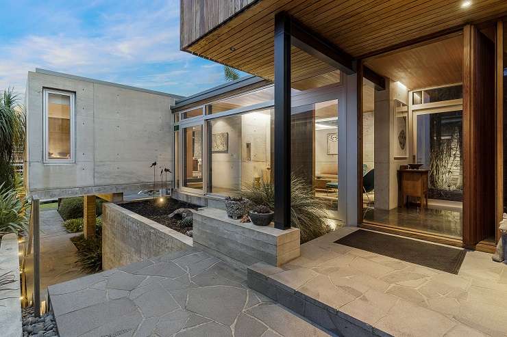 A three-bedroom house for sale on Regina Street, in Coxs Bay. The home, by architect Steven Lloyd, features concrete, glass and steel cantilevered over the carport. Photo / Supplied