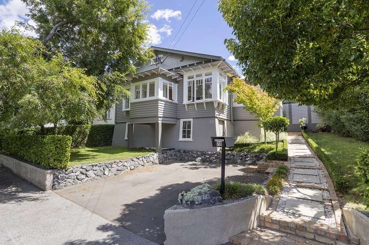 pale green villa with white trim and lights on 74 Vermont Street Grey Lynn Auckland