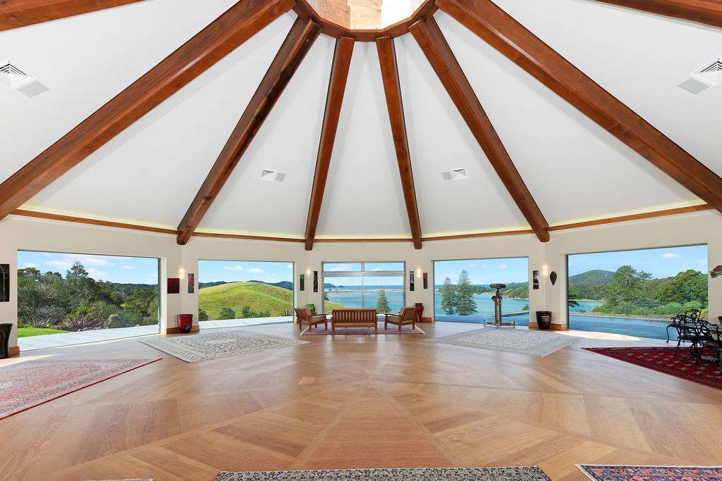 large house with circular rooms and turrets on coastal Northland property