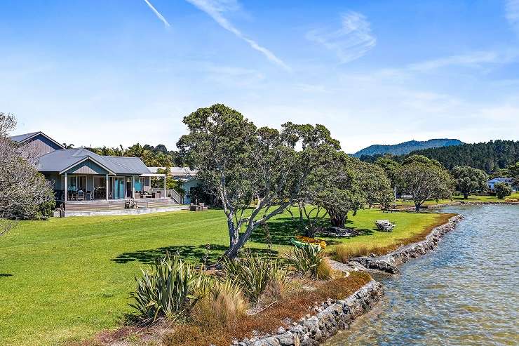 Cream house with grey roof on spreading lawn with swimming pool 51 Maungakiekie Avenue Mount Eden