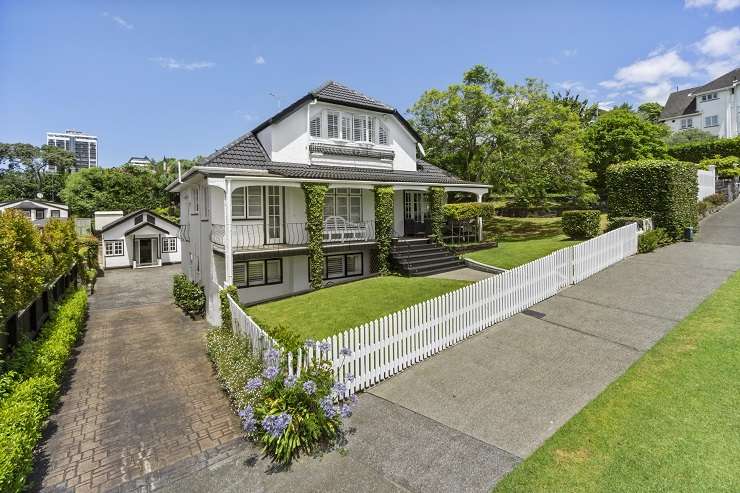 Grey villa with white picket fence and hedge at 23 Cheltenham Road, Devonport